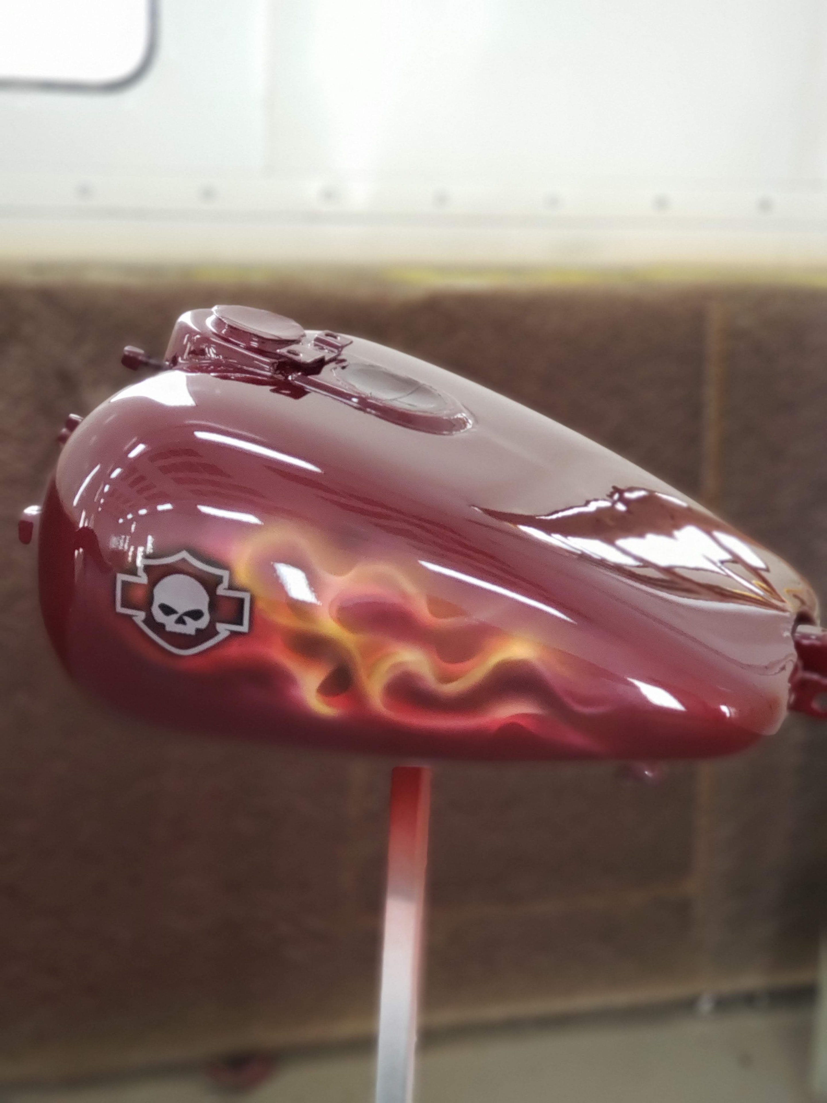 Burgundy motorcycle tank with flame and skull airbrush artwork